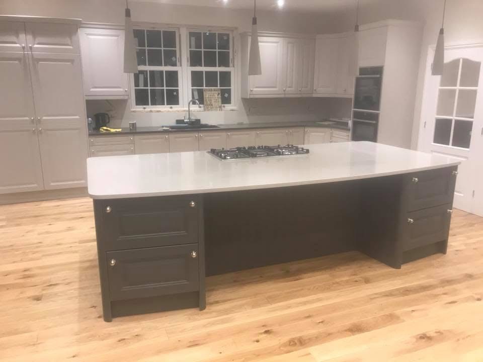Large bespoke kitchen island with dark base and light countertop