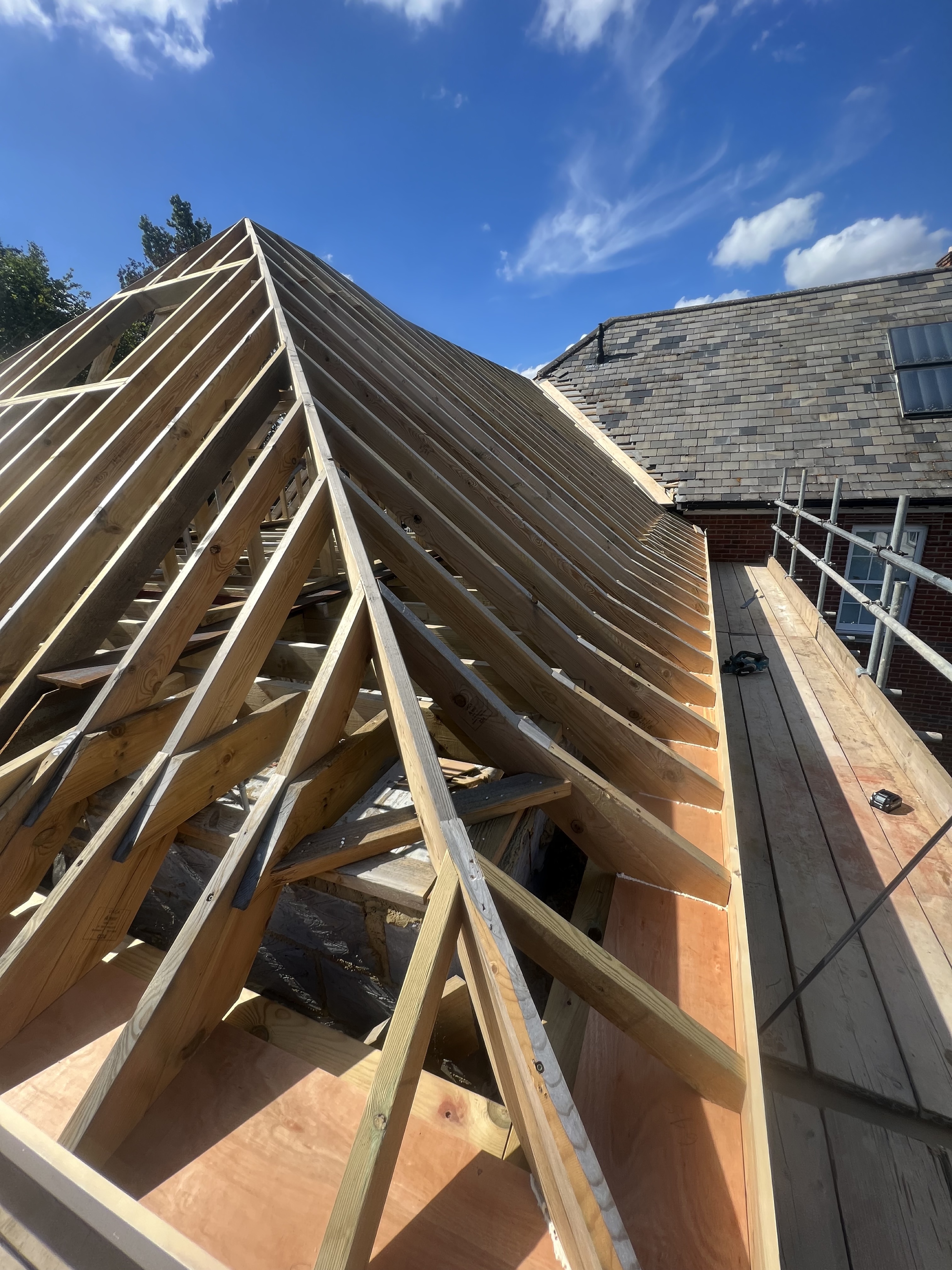 Roof truss framing project under a blue sky