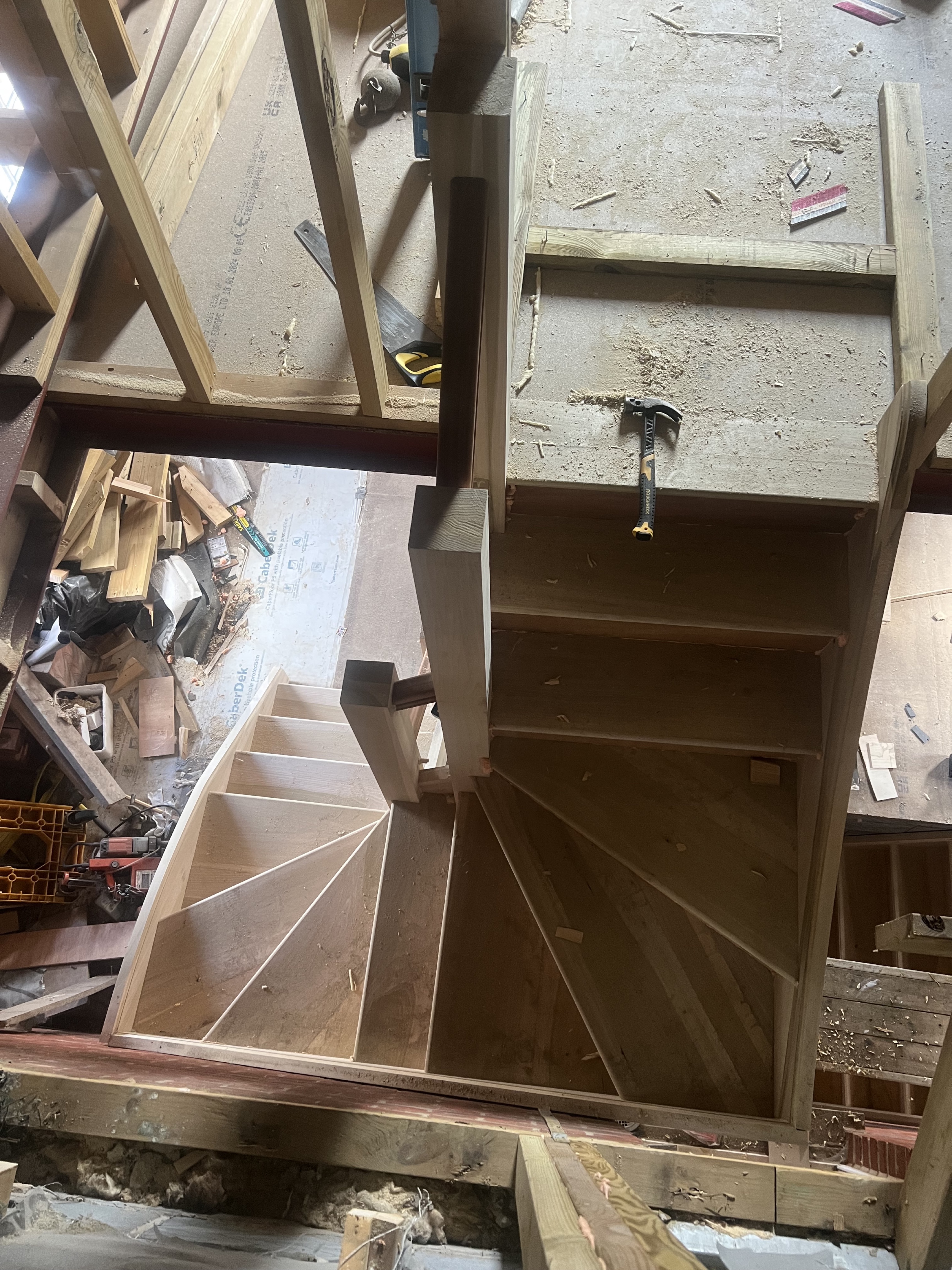 Winder staircase with pie‑shaped treads being assembled on site